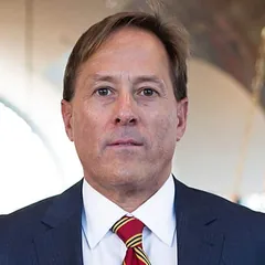 Anthony S. Pinnie, of counsel at Schuster Law, in a navy suit and a maroon and gold striped tie