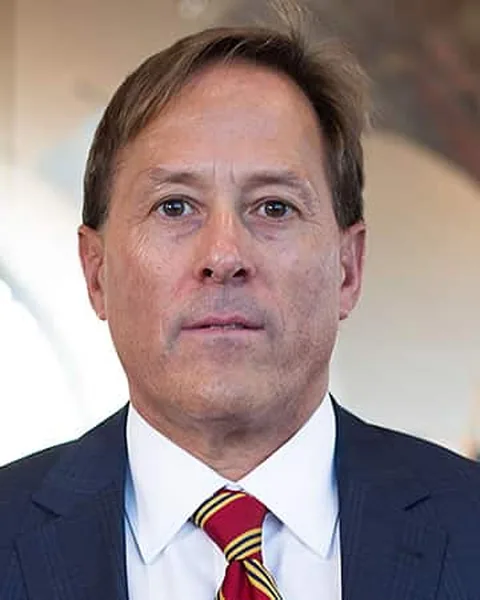 Anthony S. Pinnie, of counsel at Schuster Law, in a navy suit and a maroon and gold striped tie