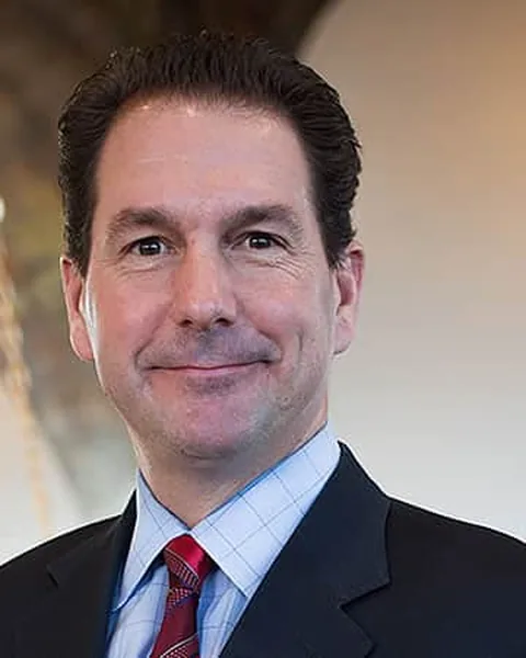 Joseph J. Jachetti, associate attorney at Schuster Law, in a dark suit and light blue shirt
