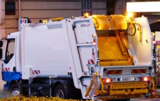 a garbage truck and sanitation worker